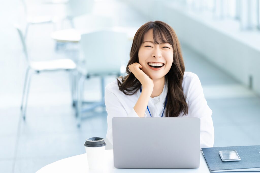 ノートパソコンを使う笑顔の女性