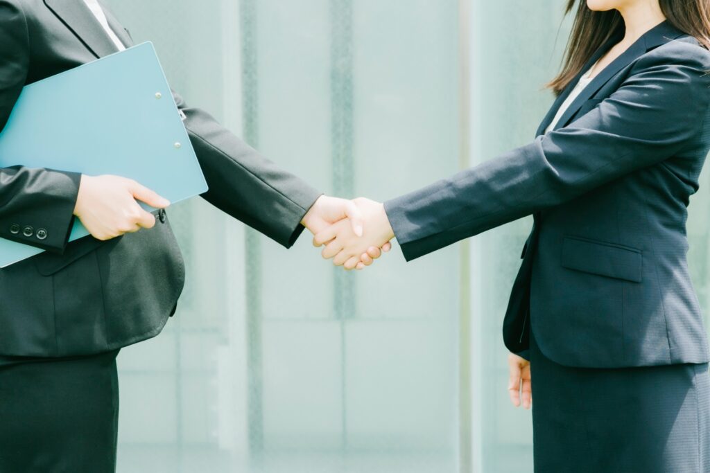 握手するビジネスウーマン(顔なし)