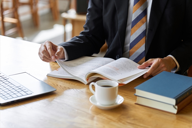勉強のためカフェで読書をするビジネスマン