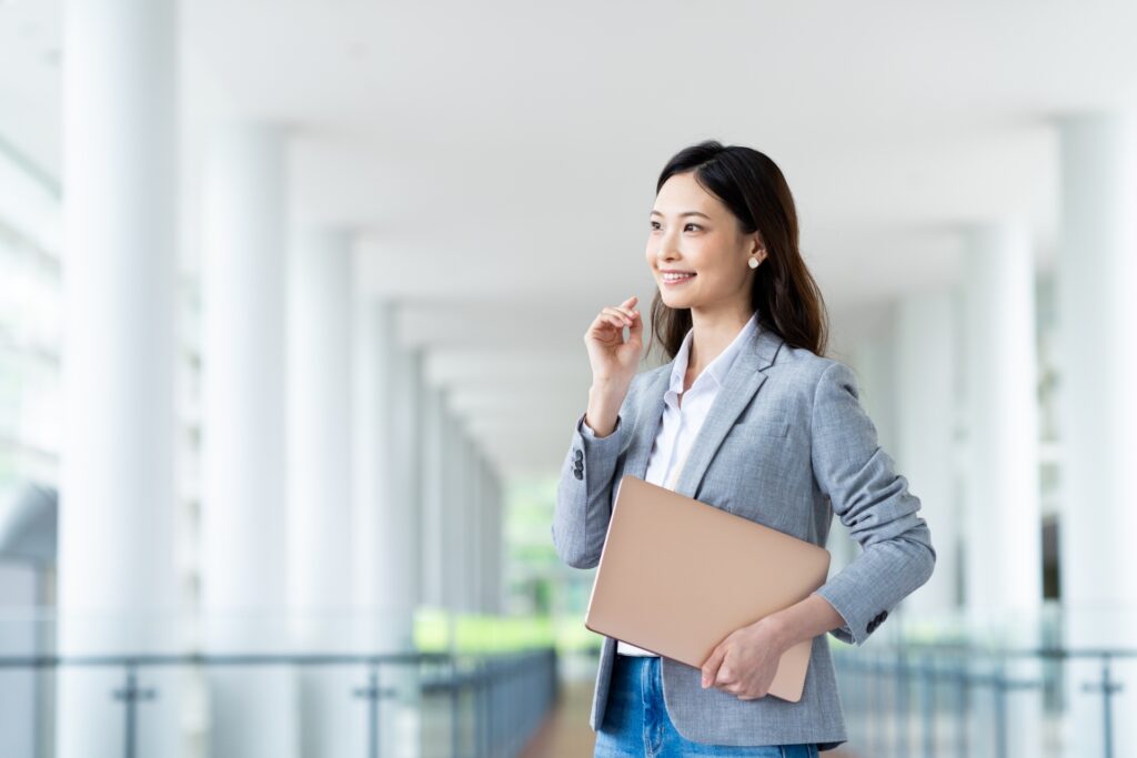 パソコンを抱えて考える女性