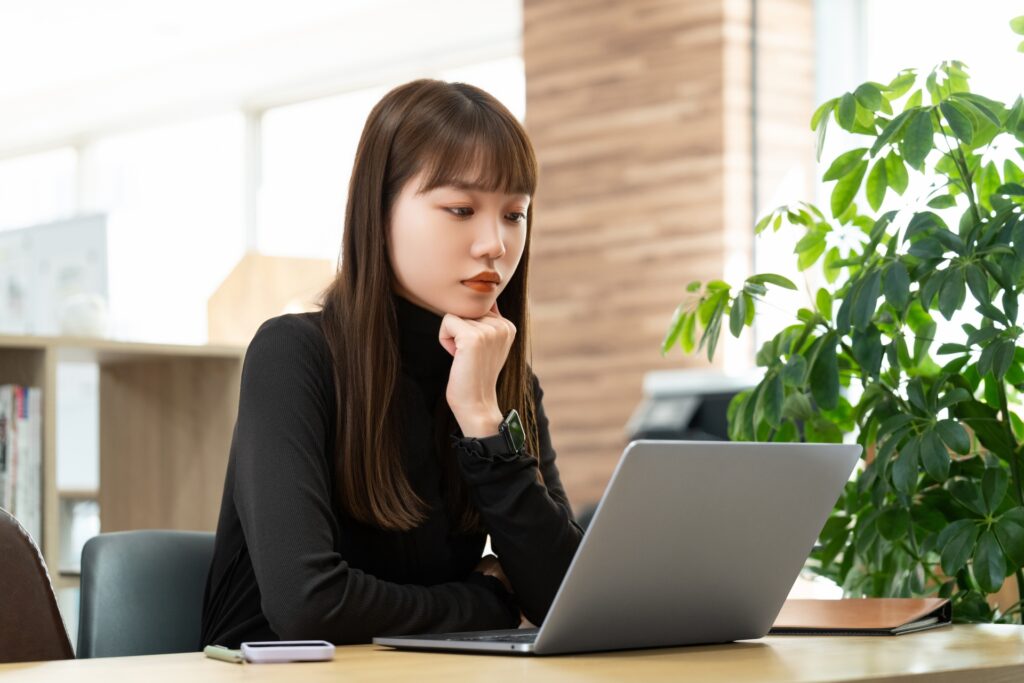 パソコンを見て考える女性