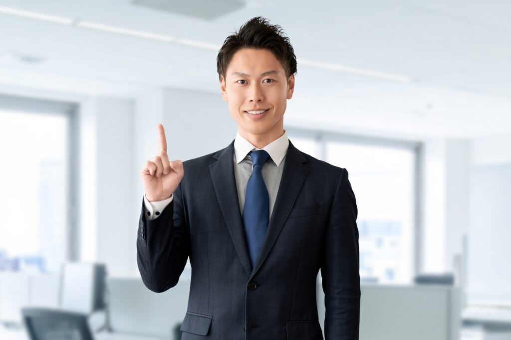 笑顔で案内する男性ビジネスマン