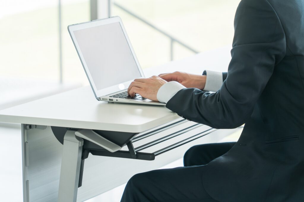 ノートパソコンでタイピングする男性の手元