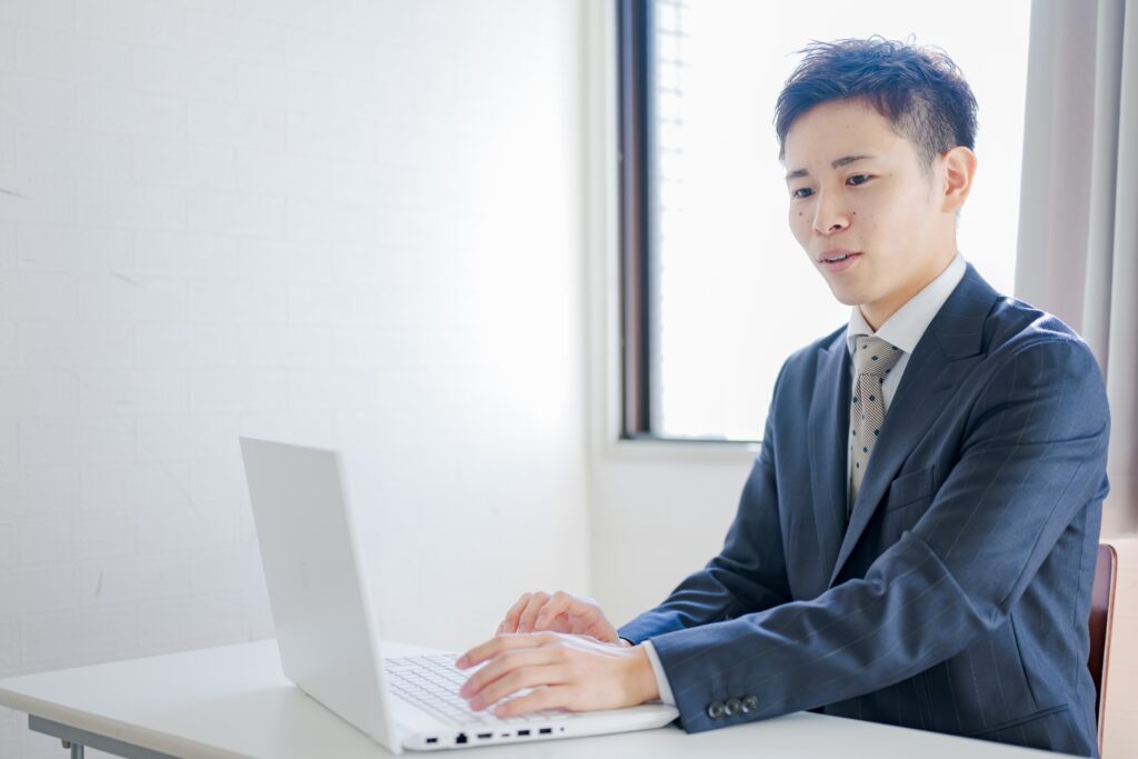 PCと爽やかなスーツ男性