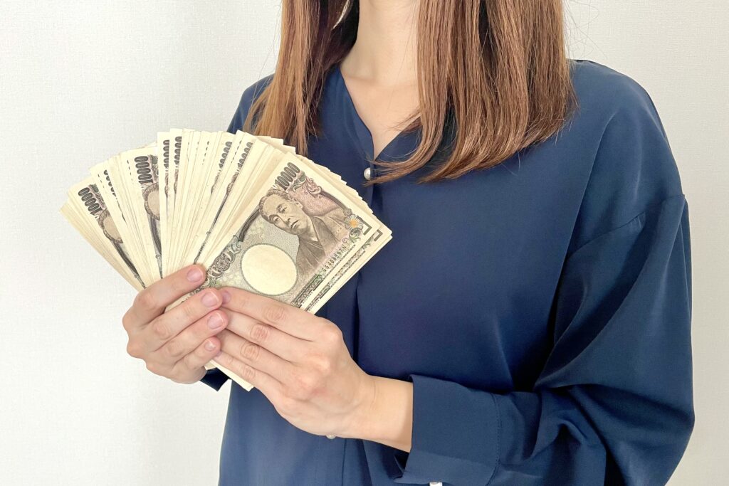 たくさんの現金を手に持つ女性