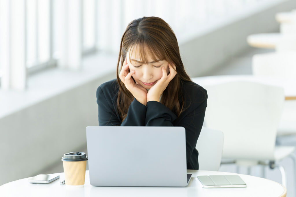 パソコンを使いながら考える女性