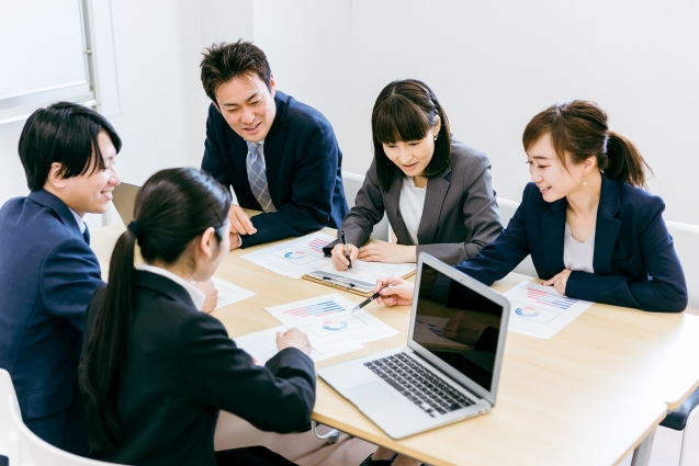 会議室でミーティングをするスーツ姿の男女