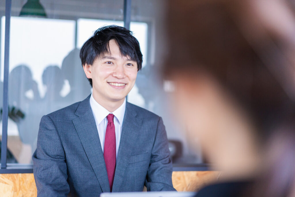 会議で発言をする若いビジネスマン