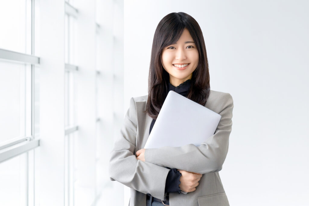 ノートパソコンを持つ笑顔の女性