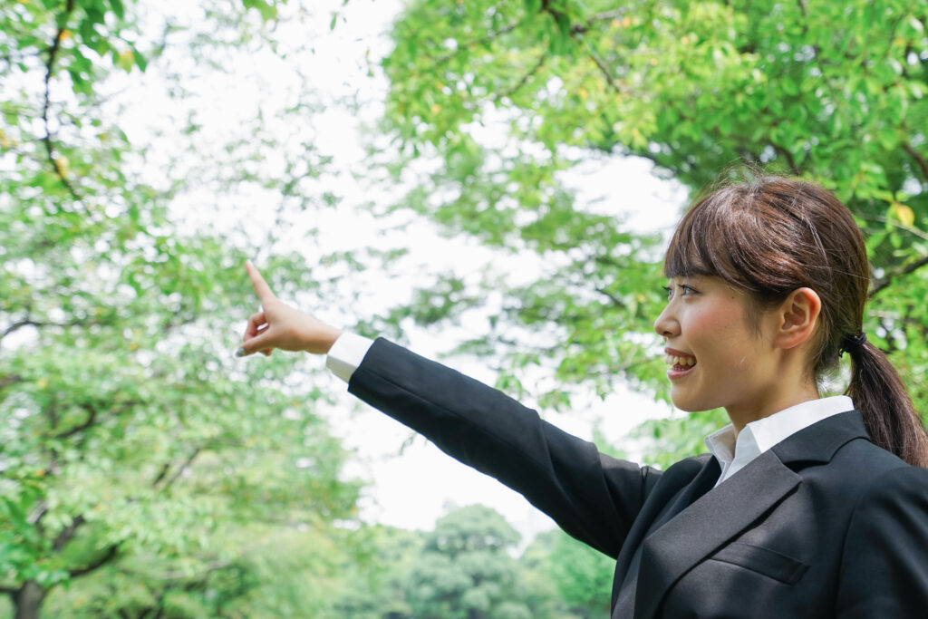 上を指さすビジネスウーマン