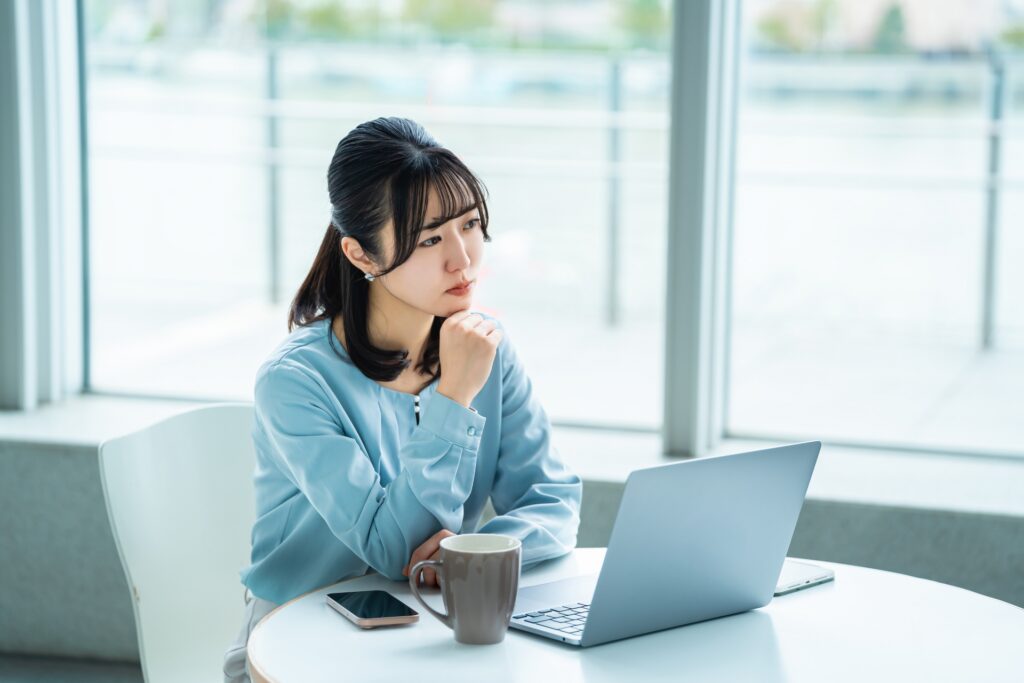 パソコンを見て考える女性ビジネスウーマン