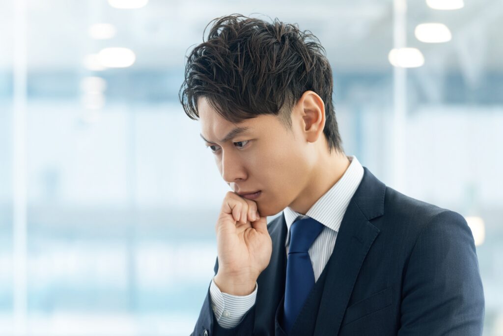 考えごとをする男性ビジネスマン