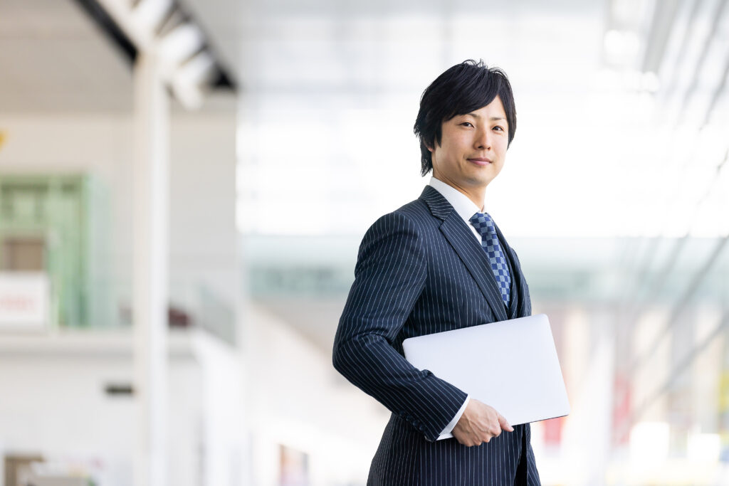 パソコンを持つスーツの男性