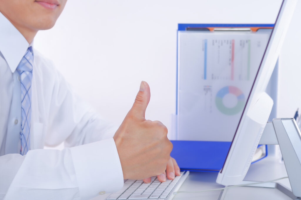 親指を立てるデスクワークの男性