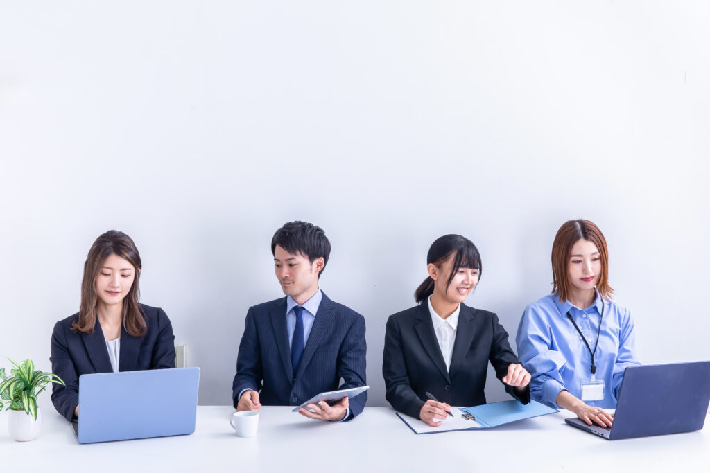 デスクワークする複数の男女