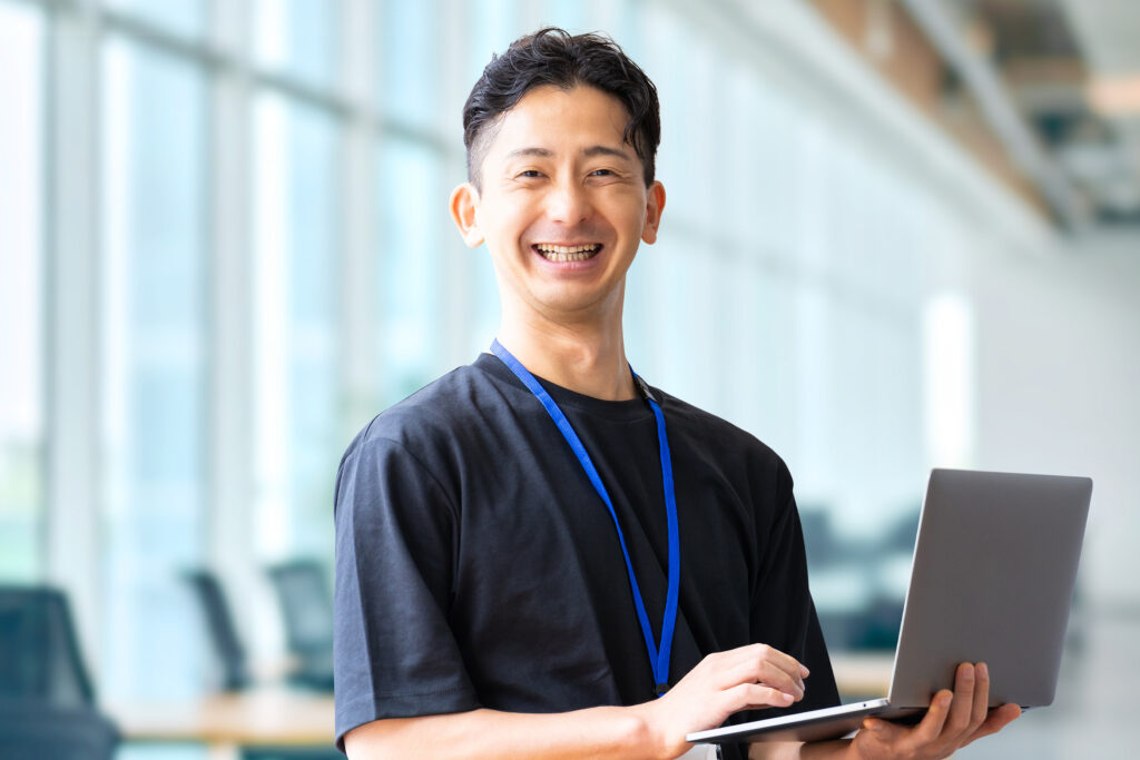 ノートパソコンを持つ笑顔のビジネスマン
