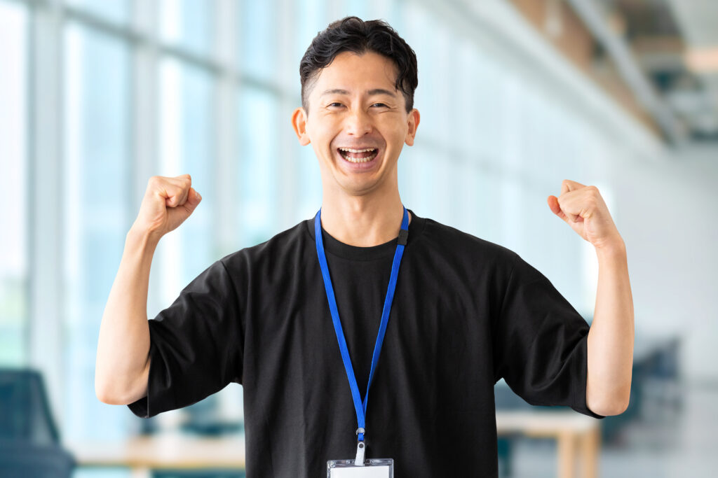 ガッツポーズで喜ぶ笑顔の男性ビジネスマン
