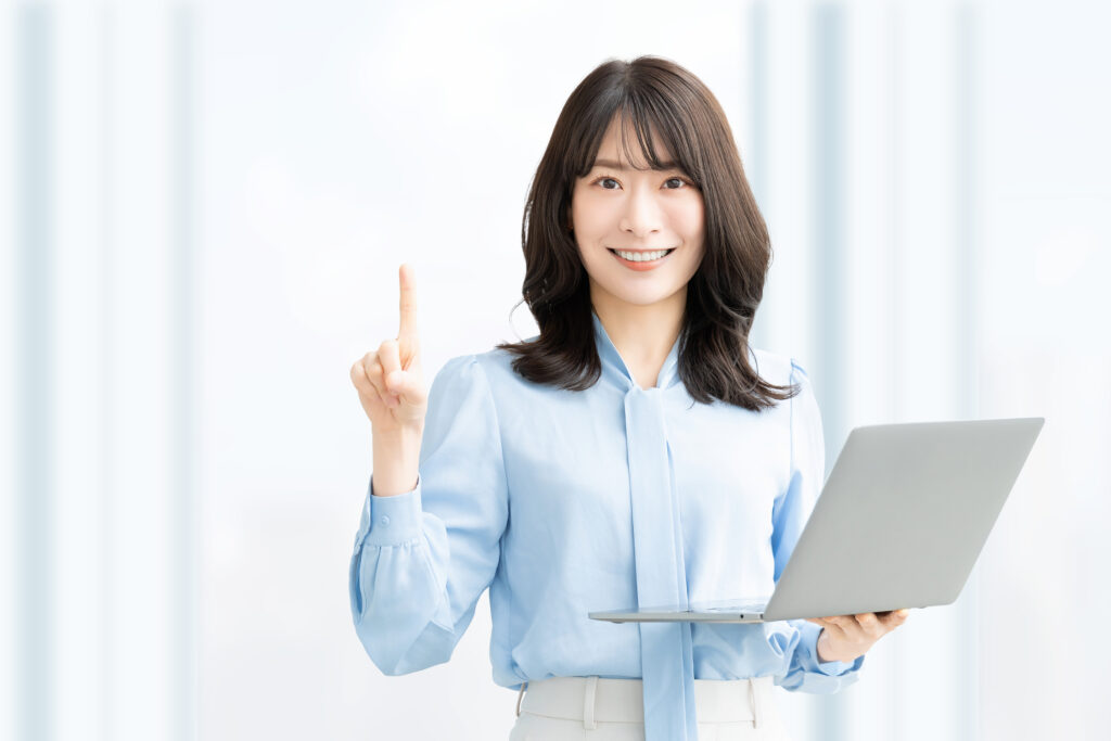 パソコンを持って案内をする笑顔の女性