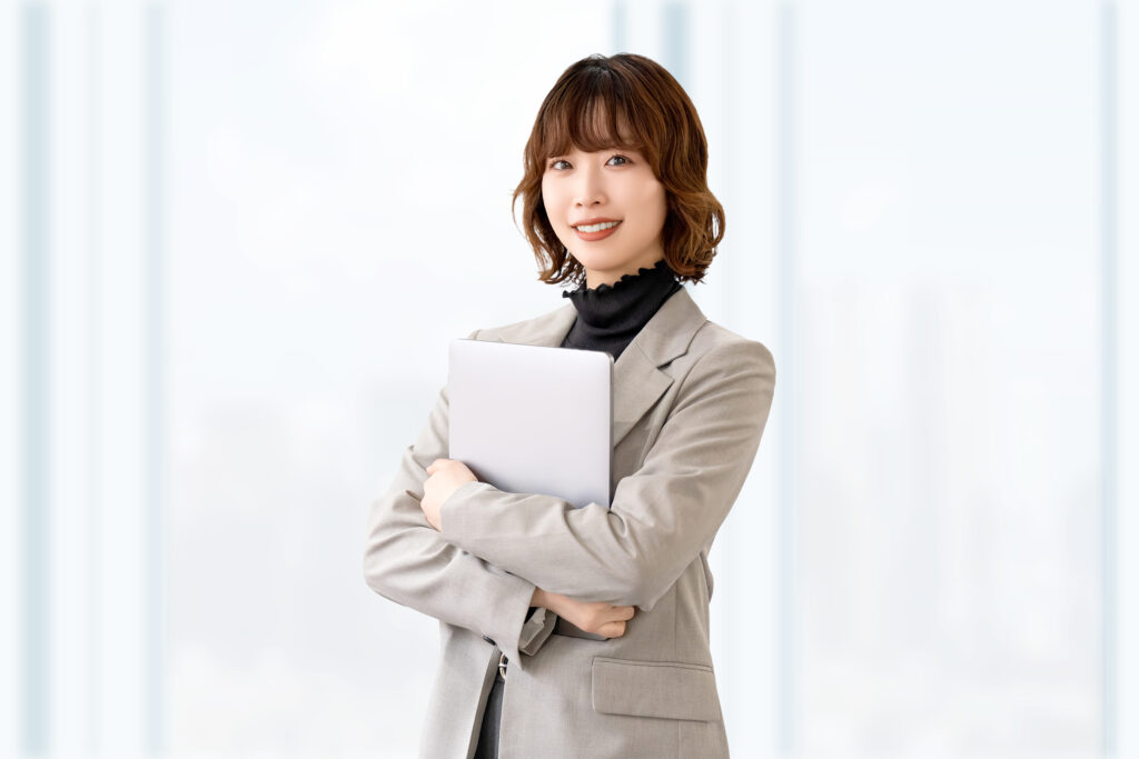 ノートパソコンを持つ笑顔の女性