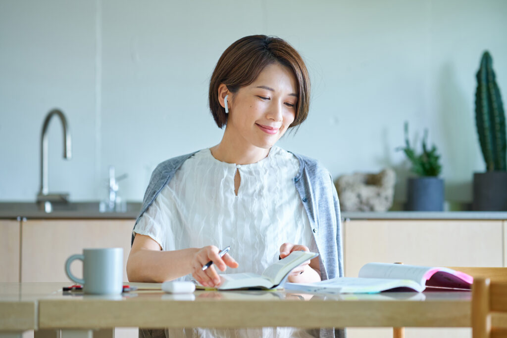イヤホンをつけて勉強をする女性