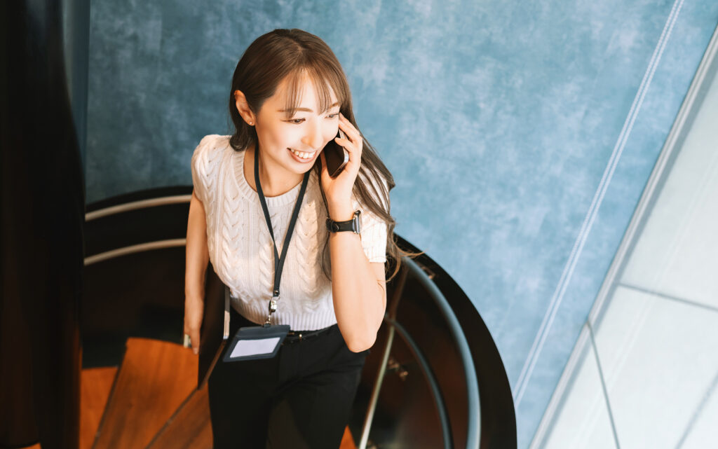 スマホで話しながら歩く笑顔の女性