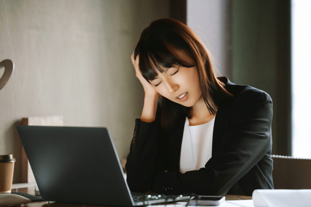 パソコンを使いながら困る女性