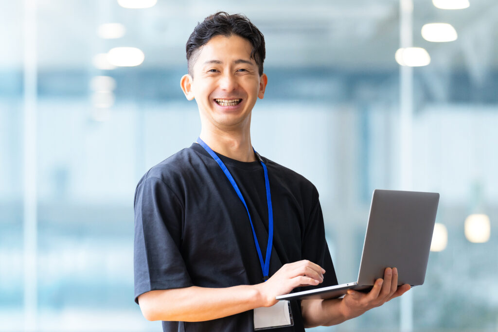 パソコンを持つ笑顔の男性ビジネスマン