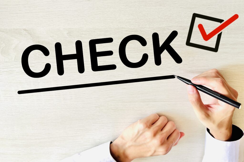 机にチェックの文字を書く手