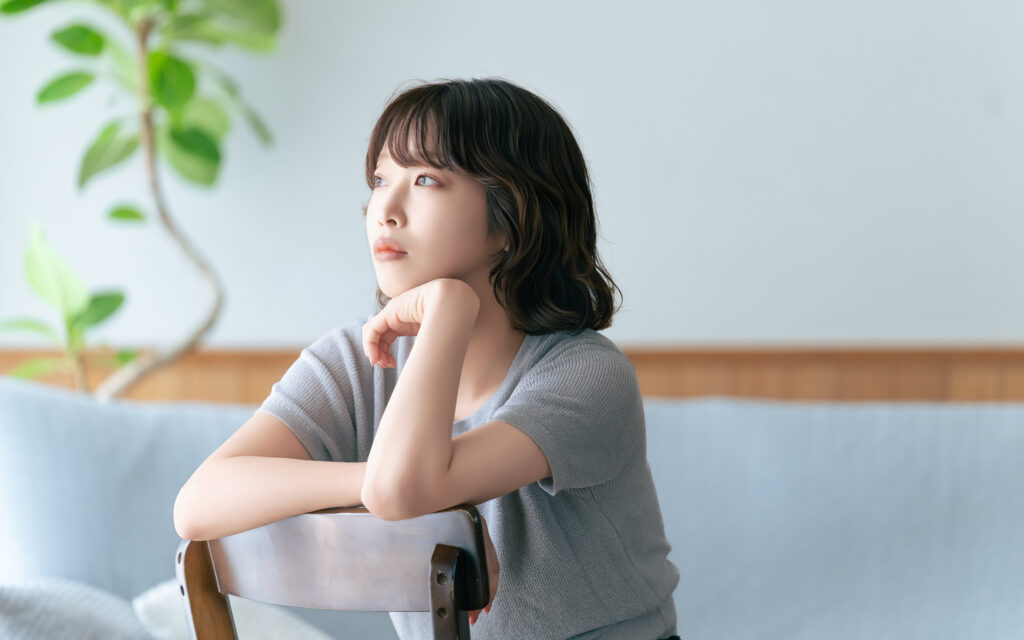 椅子に座って考えごとをする女性
