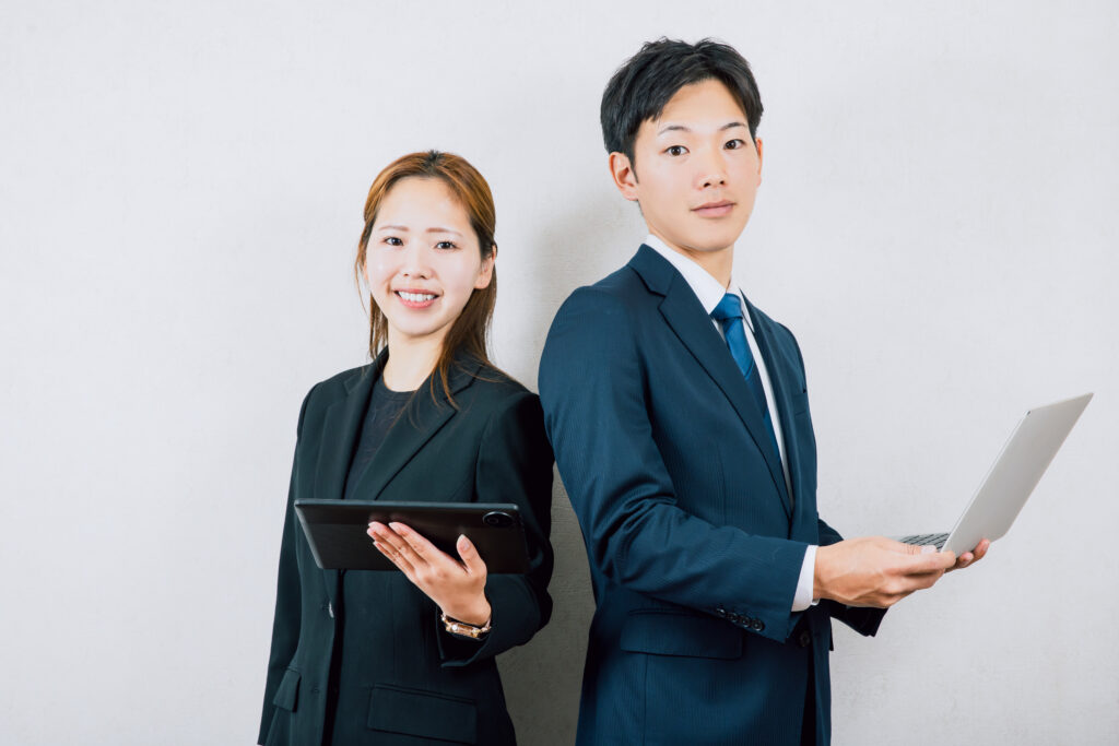 スーツを着て働くビジネスマン男女