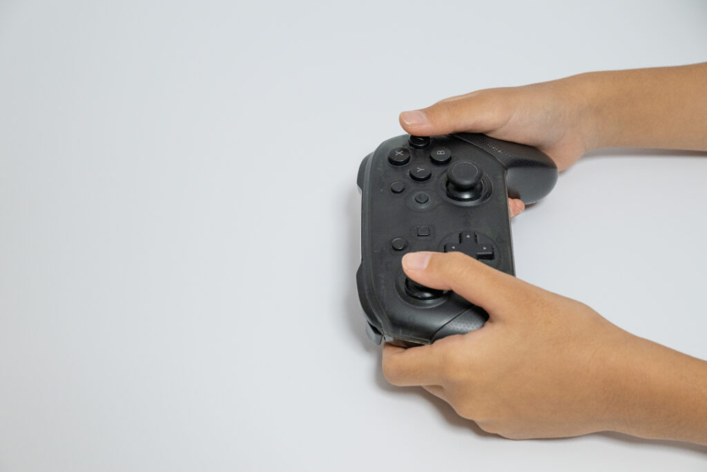 ゲームコントローラーを操作する手元