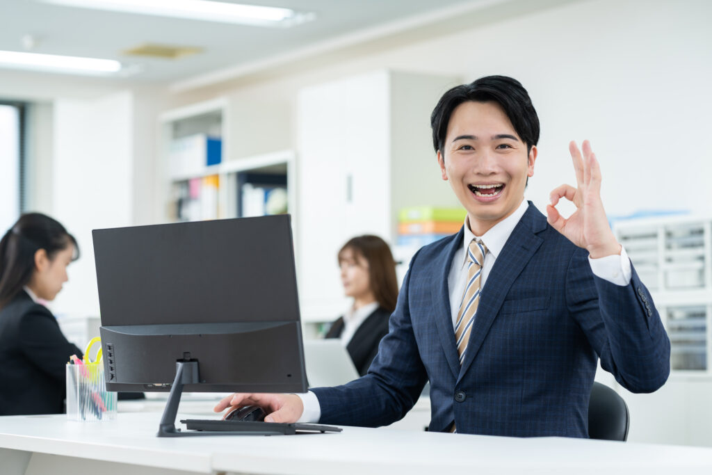 オフィスでOKサインをするビジネスマン