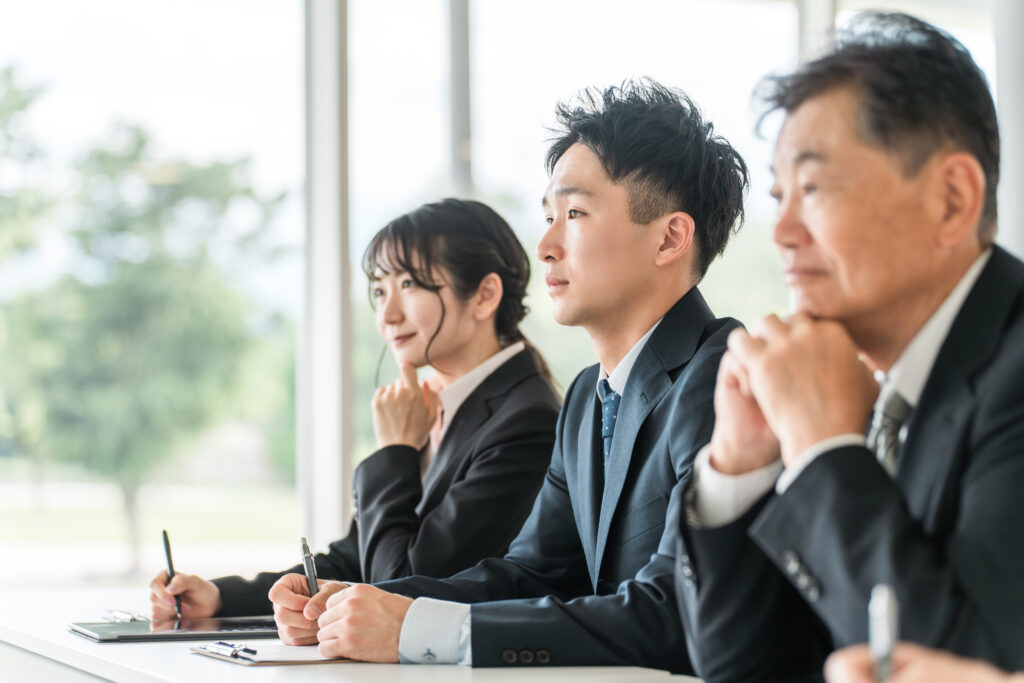 セミナーを受けるスーツ姿のシニアと若者