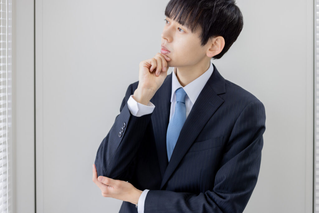 考えるアジア人の若いビジネスマン