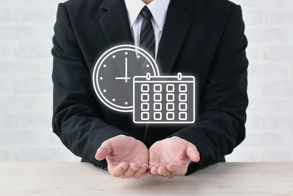 時計とカレンダーを掲げるビジネスマン