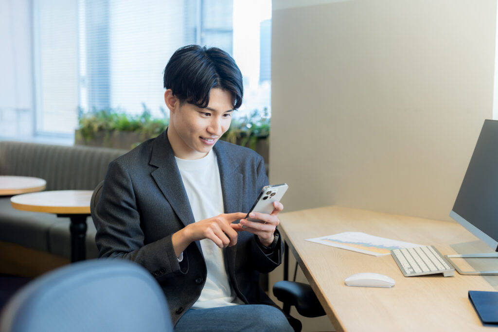 オフィスでスマホを使うビジネスマン