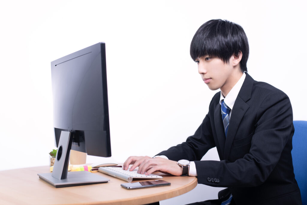 デスクトップPCで作業をする日本人男性会社員
