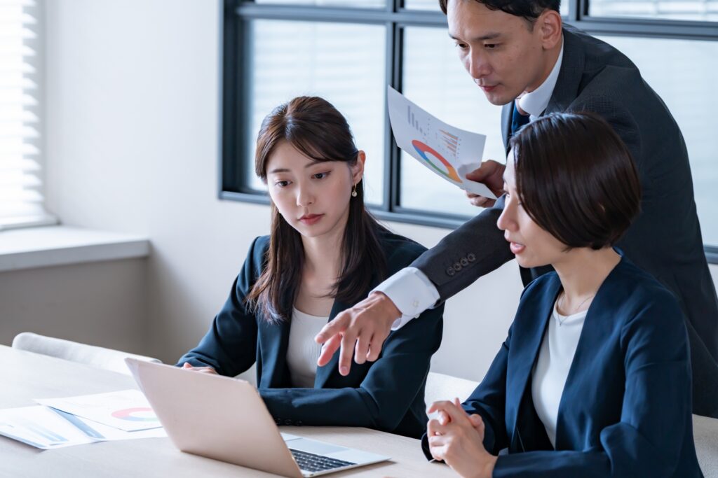 パソコンを見て議論をするビジネスマン