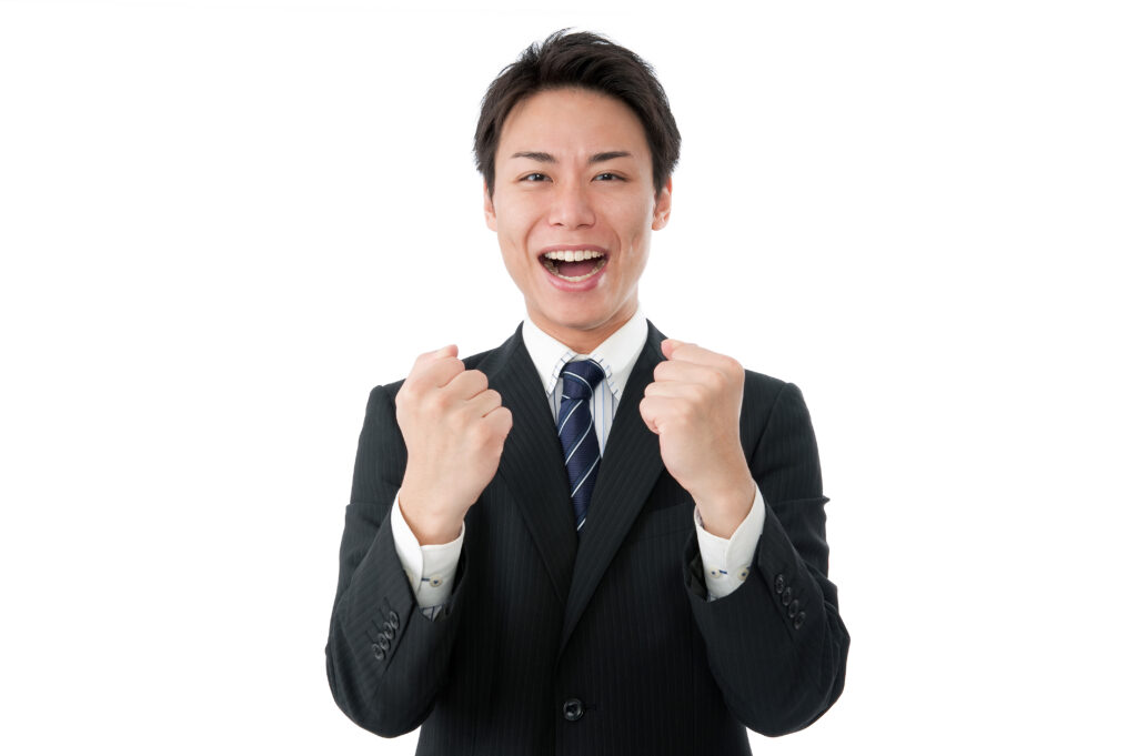両手でガッツポーズをする若いビジネスマン