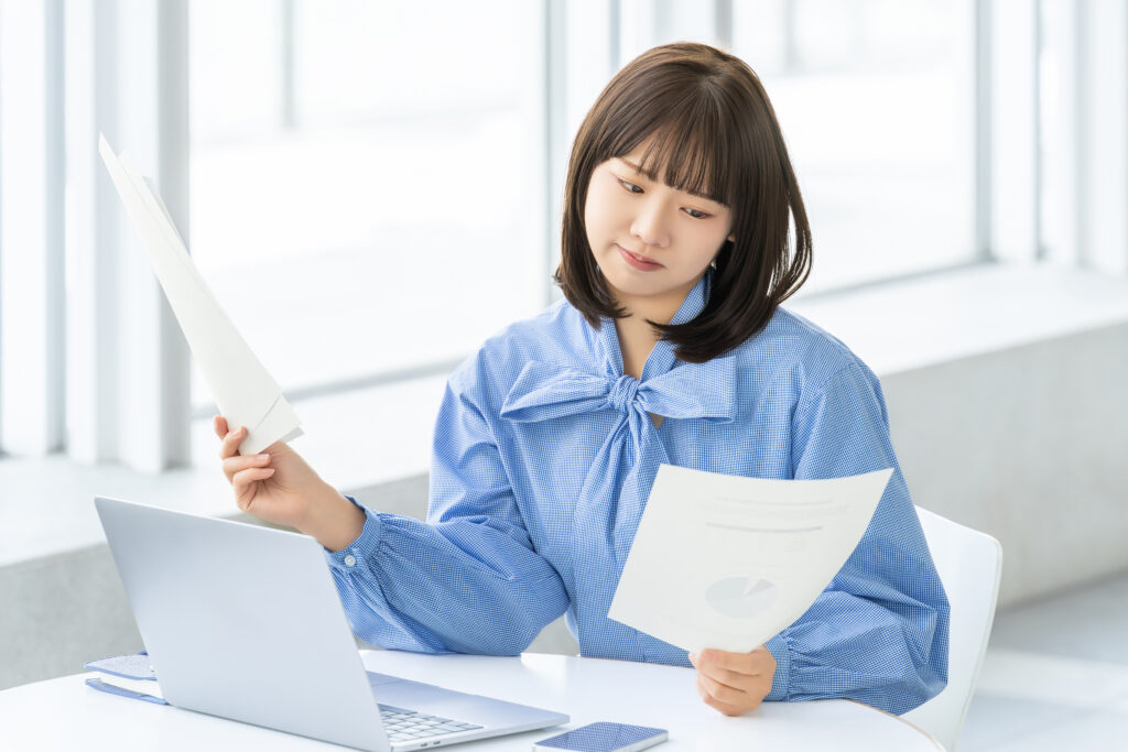 資料を見て考える女性・ビジネスウーマン