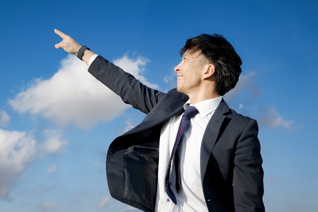 空を指さすビジネスマン